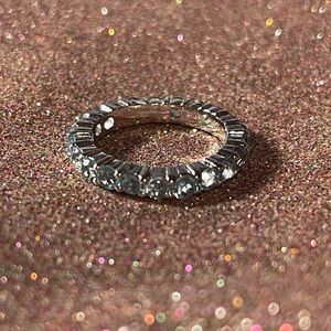 Sterling silver ring with blue stones surrounding it.